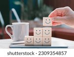 Concept of mental and emotional well-being; a happy face is displayed on the face of a wooden block cube to represent a good outlook.