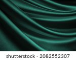  Dark blue green silk satin. Wavy soft folds. Shiny fabric surface. Luxury emerald green background with space for design. Web banner. Birthday, Christmas, Valentine, holiday, festive, paty, award.   