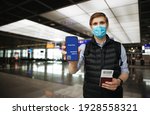 Travel Pass. Hand holding mobile Digital vaccine passport COVID-19 app. Man wearing face mask. Covid pass for traveling.  Phone in airport terminal in background. Vaccinated person ready for trip