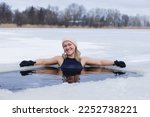 Small photo of Winter swimming. Woman in frozen lake ice hole. Swimmers wellness in icy water. How to swim in cold water. Beautiful young female in zen meditation. Gray hat and gloves swimming clothes. Nature lake