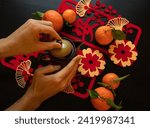 Lunar New year flat-lay with hands , oranges, pot and Chinese wishes characters 