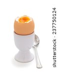 Small photo of Closeup shot of boiled egg in eggcup. Isolated on white background.