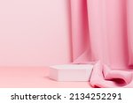 Small photo of Geometric empty podium with textile fabric drape on pink background, display for product, cosmetic and perfume presentation