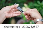 Small photo of Fingernail clipping, woman cutting nails using nail clippers concept Keeping fingernails clean.