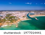 Aerial view of golden coast cliffs of portuguese southern beaches in Lagos City, Algarve, Portugal. River and marine.