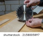 carpenter man holding a replacement carbon steel circular saw blade