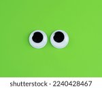 googly  cute eyes funny Isolated on bright lime green  background copy space logo