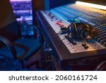 Close-up of sound mixing board with headphones on it for musical producer in studio