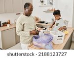 Small photo of Father showing his son hw to sort garbage