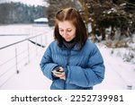beautiful woman calmly waiting, talking on the phone in a snowy landscape