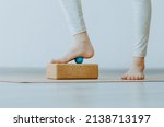 Small photo of Foot on small therapy ball on cork block for plantar fascia massage and hydration. Concept: self care practices at home, myofascial release