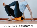 Small photo of Woman doing glute myofascial release on foam roller
