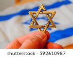Fingers Holding A Jewish Star...