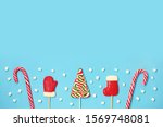 Christmas candies and mini marshmallows on blue background. candy shapes, candy cane. Flat lay, top view. Copy space