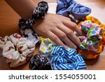 Girl's hand with textile scrunchies, hair elastic used as a fashion accessory.