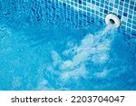 Small photo of Top view of an active underwater discharge nozzle filtration system set in a blue liner swimming pool with low water level ready for winter.