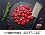 Raw organic meat ( beef or lamb ) on a black slate board. Top view with copy space.