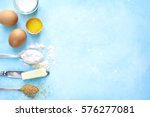 Ingredients for baking - eggs,flour,sugar,butter,milk on a light blue concrete,stone or slate background.Top view with space for text.