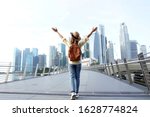  Young woman traveler with backpack and hat traveling into Singapore city downtown. Travelling in Singapore concept.                                     