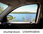Looking out the passenger side window of a car at the Diamond Hill Reservoir in Cumberland, Rhode Island on a sunny summer day.