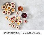 Traditional Linzer Christmas cookies filled with lingonberry jam and orange jam on wooden background