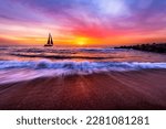 A Sailboat Is Sailing Along The Ocean With A Wave Breaking On Shore