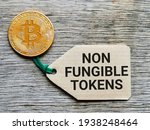 Digital currency concept. Phrase NON FUNGIBLE TOKENS written on label tag with bitcoin.
