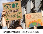Small photo of Protesters holding signs Stop Climate Change and Stop Global warming. People with placards at protest rally demonstration strike.