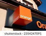 Small photo of NIEPOLOMICE, POLAND - AUGUST 14, 2023: Orange company logo sign. Telecommunications provider signboard with brand logotype at entrance to branch office building.