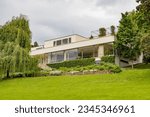 BRNO, CZECH REPUBLIC (CZECHIA) – JUNE 6, 2023: Exterior of the functionalist Villa Tugendhat (Vila Tugendhat) and its garden on a cloudy day, South Moravian Region (Jihomoravský kraj)
