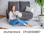 A girl with a beautiful bouquet is sitting on the floor