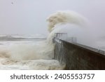 Small photo of Huge Waves battering a sea defence wall during a storm at Hartlepool Headland, County Durham, England, UK.