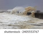 Small photo of Huge Waves battering a sea defence wall during a storm at Hartlepool Headland, County Durham, England, UK.