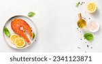 Small photo of Fresh raw salmon steaks with spices, lemons and pink salt on white plate. Top view of fish with copy space. Keto recipe.