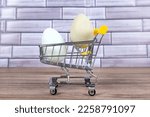 Green and blue farm fresh eggs in a tiny shopping cart