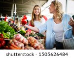 Young happy women shopping vegetables and fruits on the market