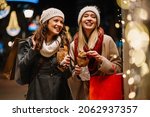 Portrait of happy women friends enjoying shopping together outdoors. Christmas shopping