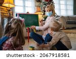 Small photo of Childminder with mask and children playing together. Education, coronavirus concept