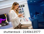 Portrait of happy young woman buying a new smartphone in store. Shopping a new digital device