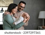 Portrait of young happy man and woman holding newborn cute baby. Happy family concept