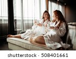 Women in bathrobes enjoying tea during wellness weekend