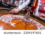 The dealer holds a ball and spins the roulette wheel in a casino.