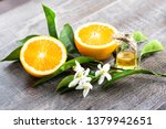 Small photo of Juicy Orange cut in two parts and neroli, flowers of orange tree, on rustic wood background. The Orange blossom is the fragrant flower of the Citrus is used in perfume and tea, aphrodisiac.