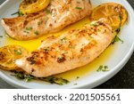 grilled chicken with butter, lemon and garlic on white plate