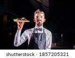 Small photo of Professional friendly flunky helpfully serves salad at a festive event.