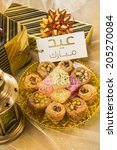 Small photo of 'Eid Mubarak' message in arabic script on a tag along with gift packs and assorted sweet