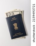 Small photo of US Dollar currency notes placed inside Indian Passport booklet in white background. Conceptual photo to connote Indian travels to USA or earn dollars.