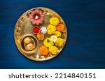 Small photo of Top view of a Puja Thali for Hindu religious rituals. Flowers, diya, Prasad and kumkum in brass plate or Thali for Hindu auspicious occasions. Hindu religious objects.