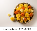 Small photo of A vintage brass bowl filled with fresh, golden colored Marigold flowers. Top view of Marigold flowers for Indian festive occasions.