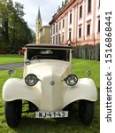 Small photo of Kunin, Czech Republic - 09-28-2019: 9th St. Wenceslas Ride ("Svatovaclavska vyjizdka"). Creamy white Tatra 57 at the car exhibition before the start outside Chateau Kunin (building in the background).